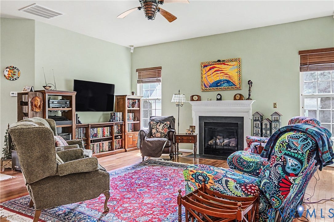 Family Room Featuring HW Floors, Gas Fireplace, and Ceiling Fan.