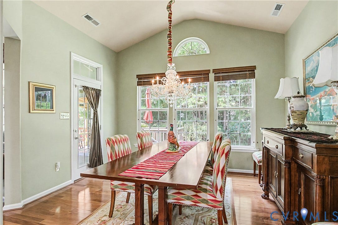 Dining Room Featuring HW Floors, Triple Windows, and Crystal Chandelier.