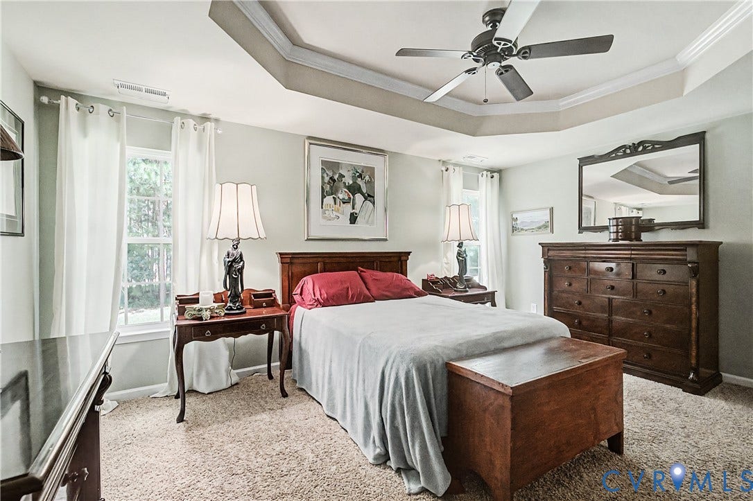 Primary Bedroom Featuring Beautiful Tray Ceiling with Crown Molding.