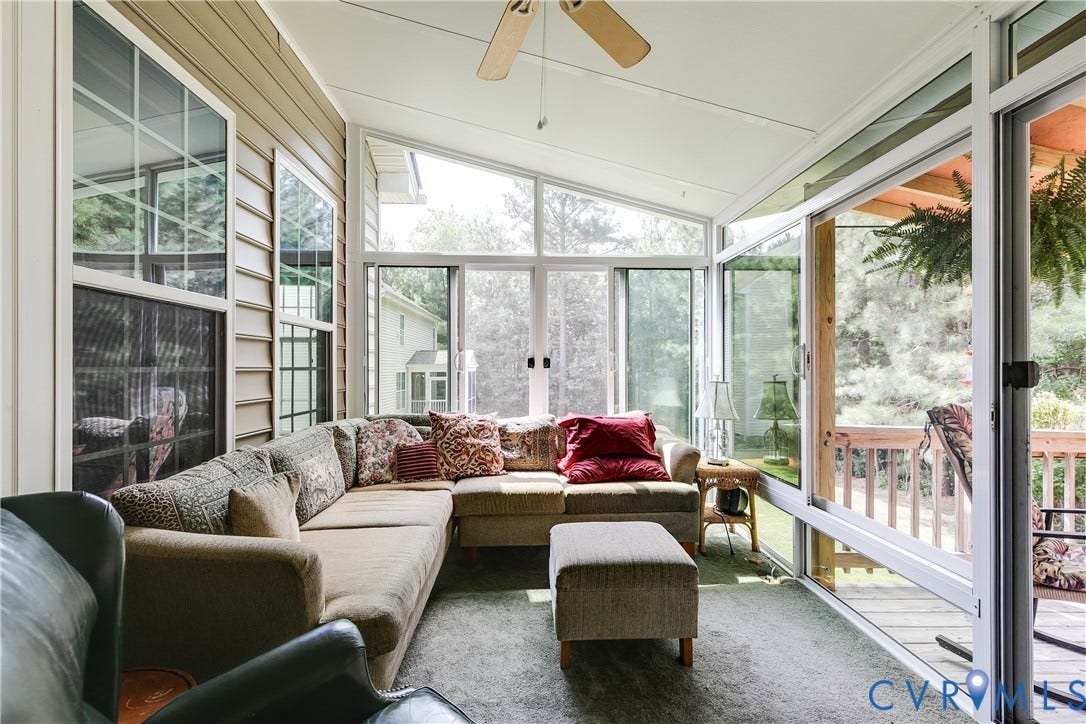 Fully Glass Enclosed Florida Room Featuring Carpet and Ceiling Fan.