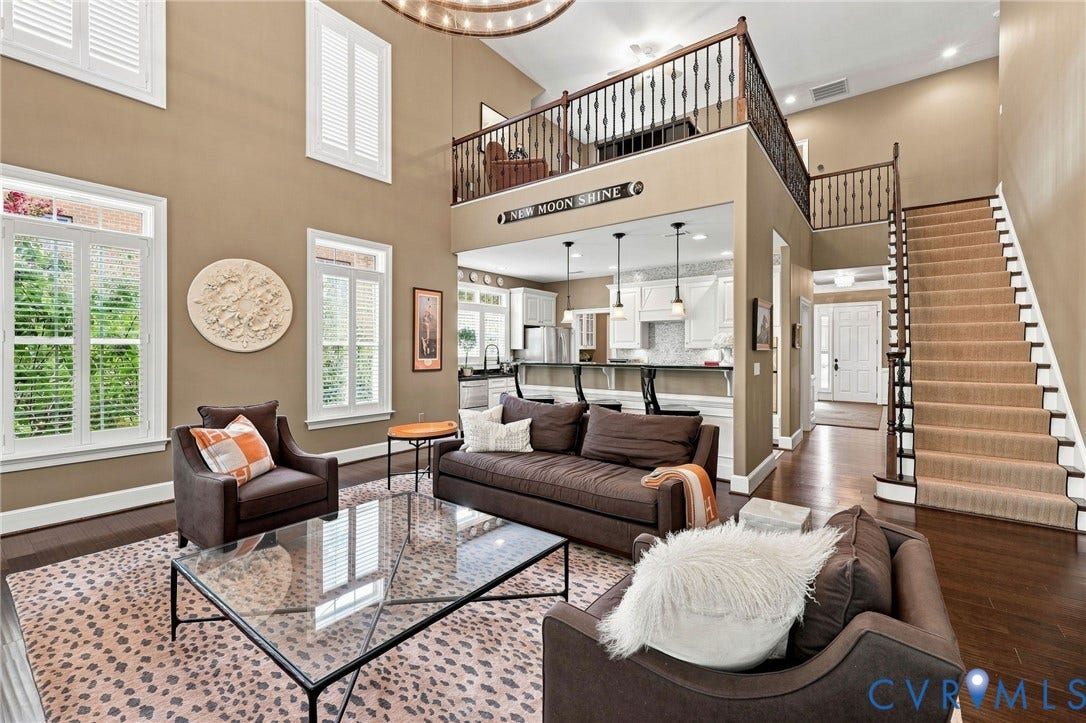 11762 Triple Notch Terrace, Three Notch Place, Henrico, VA 23233 Two-story living area with dark wood-finish flooring, white plantation shutters, and a prominent staircase with carpeted treads