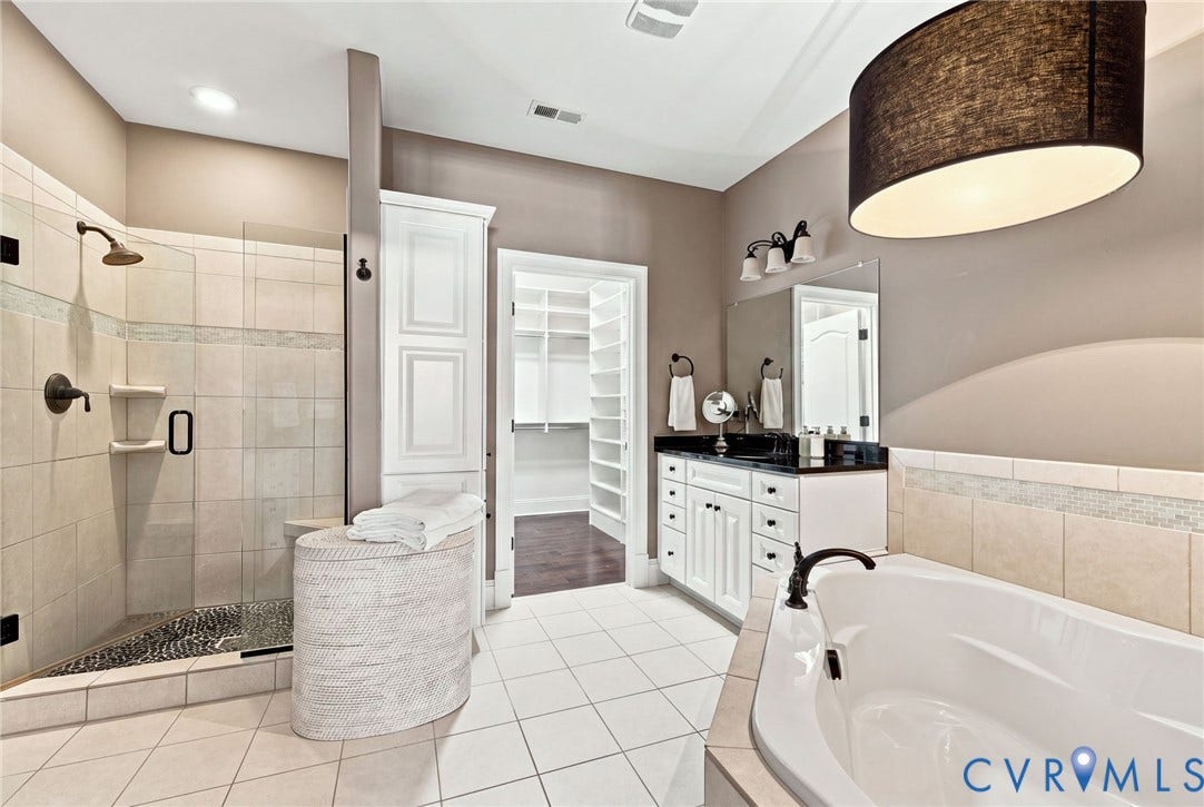 11762 Triple Notch Terrace, Three Notch Place, Henrico, VA 23233 Spacious bathroom featuring a built-in soaking tub, a separate tiled shower with a glass enclosure, white vanity cabinetry with a dark countertop, and a large walk-in closet
