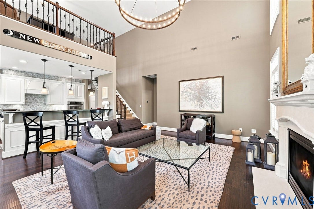 11762 Triple Notch Terrace, Three Notch Place, Henrico, VA 23233 Vaulted ceiling with an illuminated circular fixture, dark wood-finish flooring, white fireplace with hearth, and a kitchen bar with pendant lighting