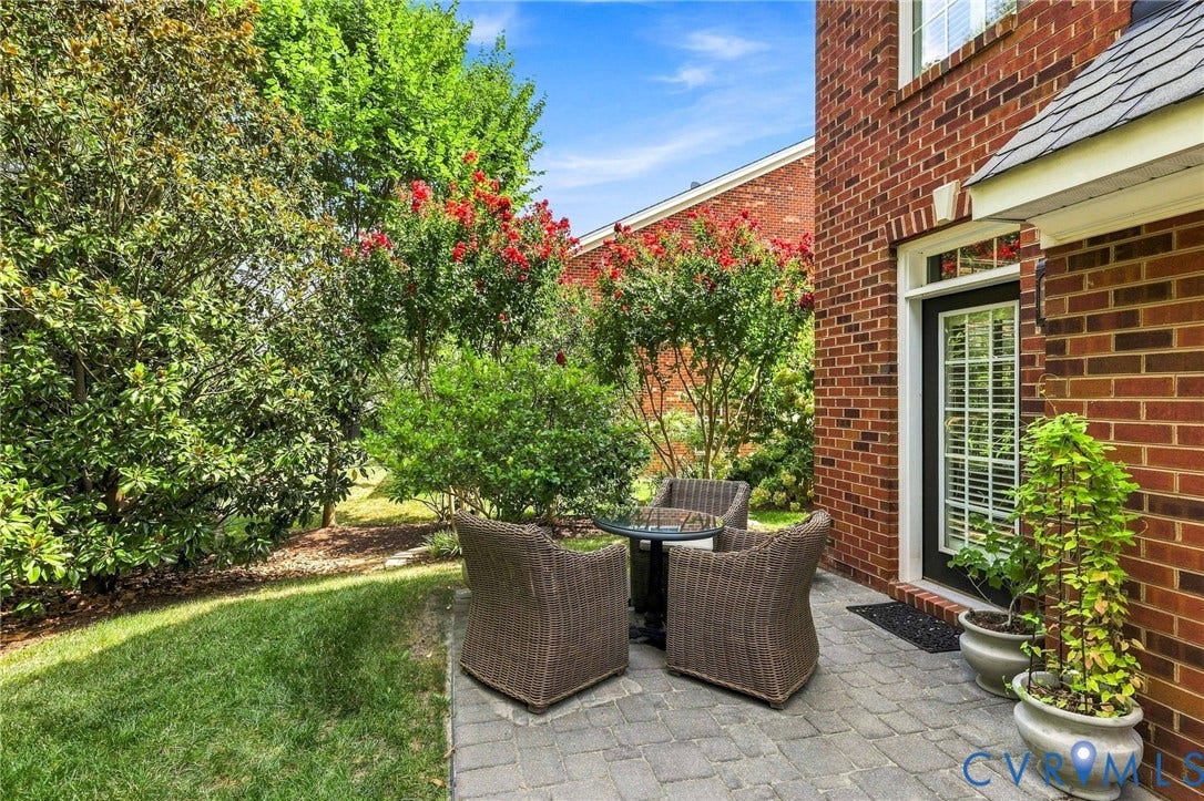 11762 Triple Notch Terrace, Three Notch Place, Henrico, VA 23233 Brick exterior with a paved patio, a black framed door with glass panels, and mature landscaping with red flowering shrubs