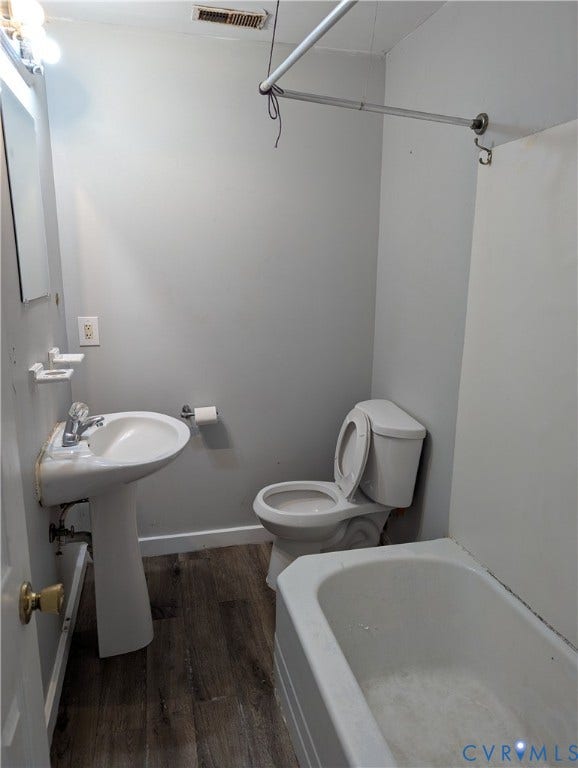 2218 Concord Avenue, Richmond, VA 23234 Pedestal sink, wall-mounted mirror, white toilet, white bathtub, and wood-finish flooring
