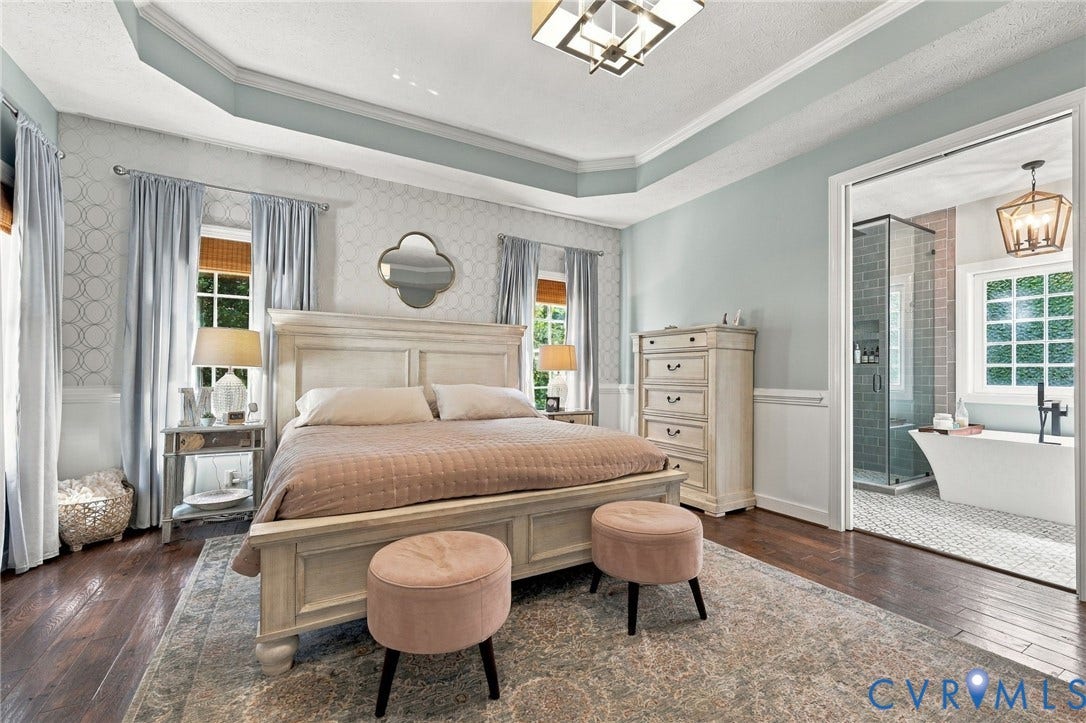 8301 Macandrew Terrace, Chesterfield, VA 23838 Tray ceiling with crown molding, wood-finish flooring, two large windows, white paneled wainscoting, and an en-suite bathroom with a freestanding tub and glass-enclosed shower