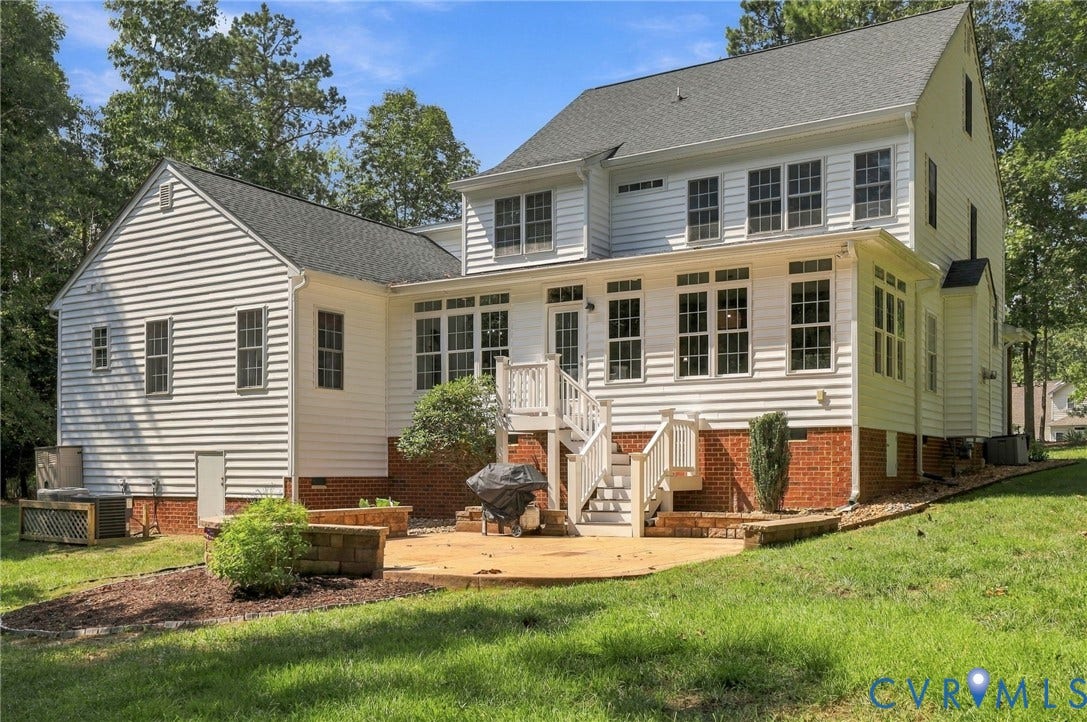 8301 Macandrew Terrace, Chesterfield, VA 23838 White siding exterior with a dark shingle roof, a ground-level patio, and a tiered deck