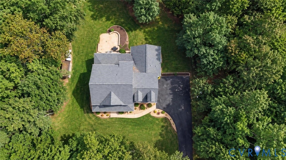 8301 Macandrew Terrace, Chesterfield, VA 23838 Expansive property featuring a grey shingle roof, paved driveway, mature trees, and a stone patio