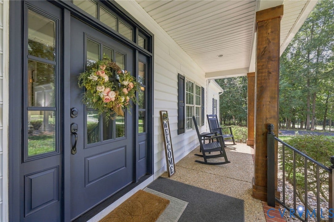 8301 Macandrew Terrace, Chesterfield, VA 23838 Welcoming front porch featuring a dark paneled entry door with sidelights, durable vinyl siding, exposed wood support columns, and an aggregate concrete surface