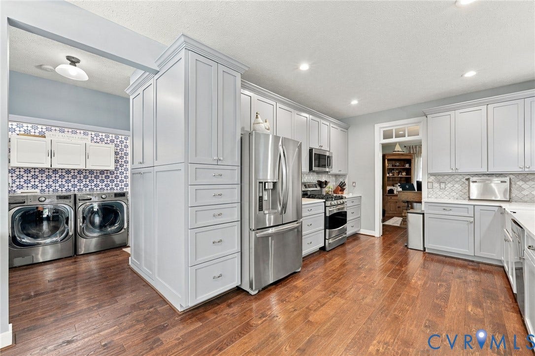 8301 Macandrew Terrace, Chesterfield, VA 23838 Wood-finish flooring, recessed lighting, light-toned cabinetry, stainless steel appliances, and patterned tile backsplash