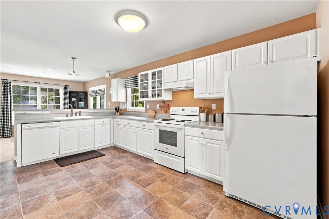 12309 Maybrook Lane, Wyndham, Glen Allen, VA 23059 Spacious kitchen featuring white cabinetry with glass-front upper cabinets, stainless steel appliances including a double-door refrigerator and electric range, laminate countertops, an undermount sink with chrome fixtures, and stone-finish flooring throughout