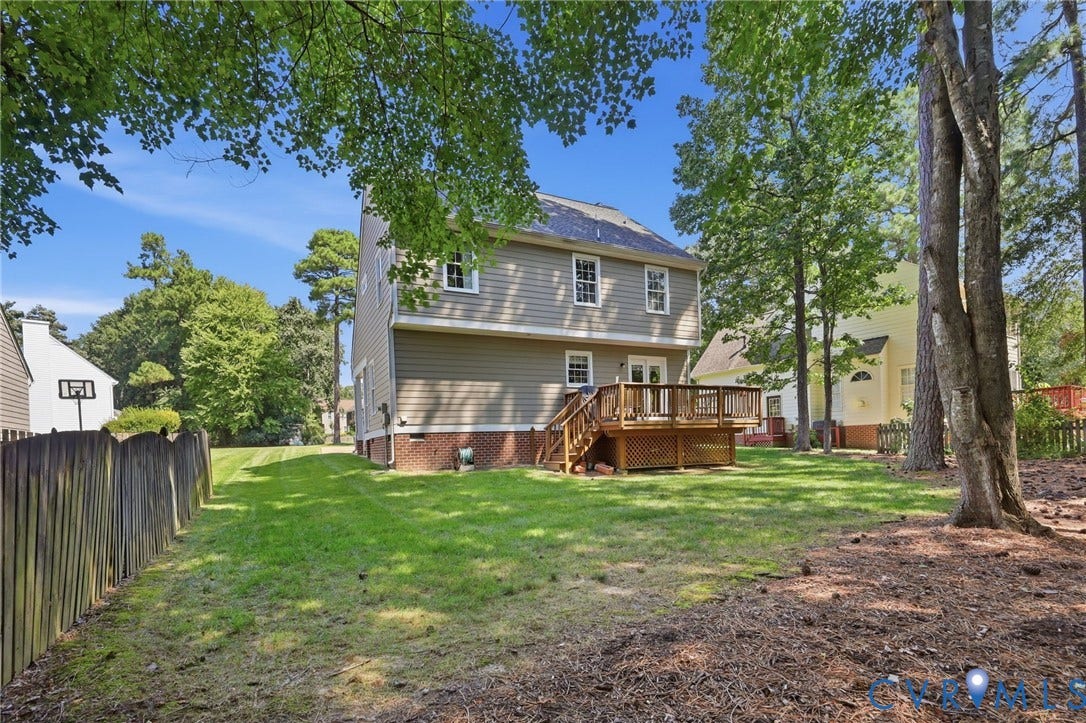 12309 Maybrook Lane, Wyndham, Glen Allen, VA 23059 Expansive backyard featuring a manicured lawn, a multi-level wood deck, a wood privacy fence, mature trees, and a two-story exterior with siding