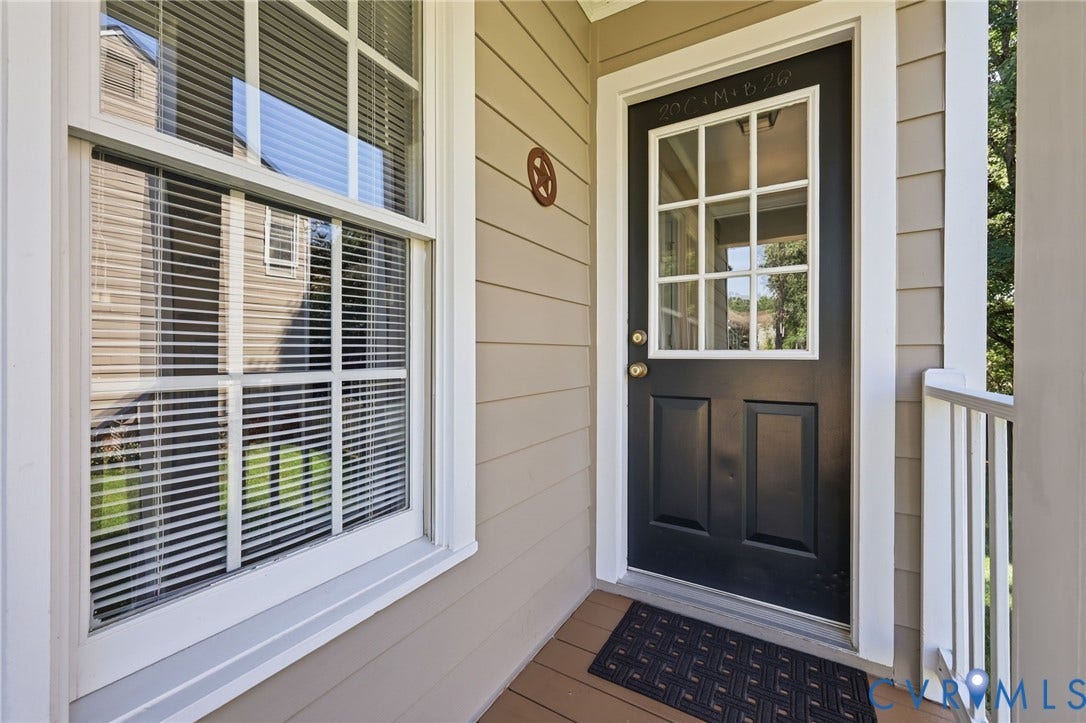 12309 Maybrook Lane, Wyndham, Glen Allen, VA 23059 Black front door with a window pane insert, light-colored siding, and a white framed window