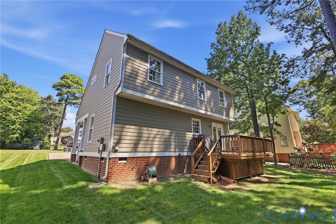 12309 Maybrook Lane, Wyndham, Glen Allen, VA 23059 Brown siding exterior with a brick foundation, featuring a multi-level wood deck, white window trim, and a manicured lawn