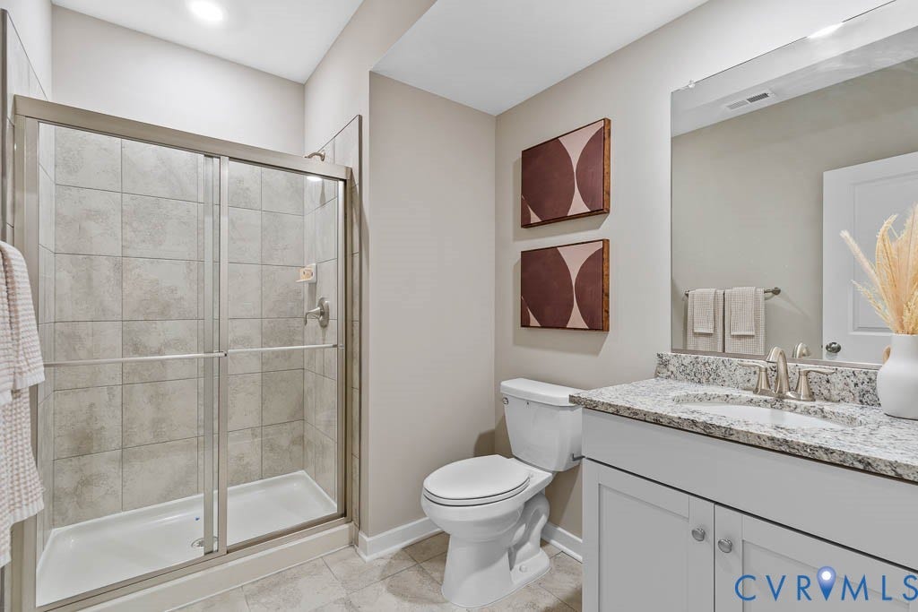 16056 Greenhart Drive, Chesterfield, VA 23832 Enclosed shower with sliding glass doors, a vanity with white cabinetry, a light-toned granite-finish countertop, and a built-in sink