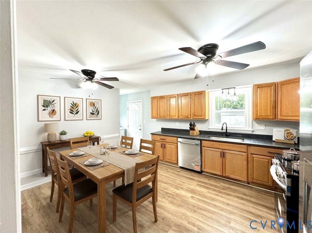 2711 Cheatham Street, Henderson & Johnson, Richmond, VA 23234 Open concept kitchen and dining area featuring wood-finish flooring, wood cabinetry with dark countertops, and stainless steel appliances