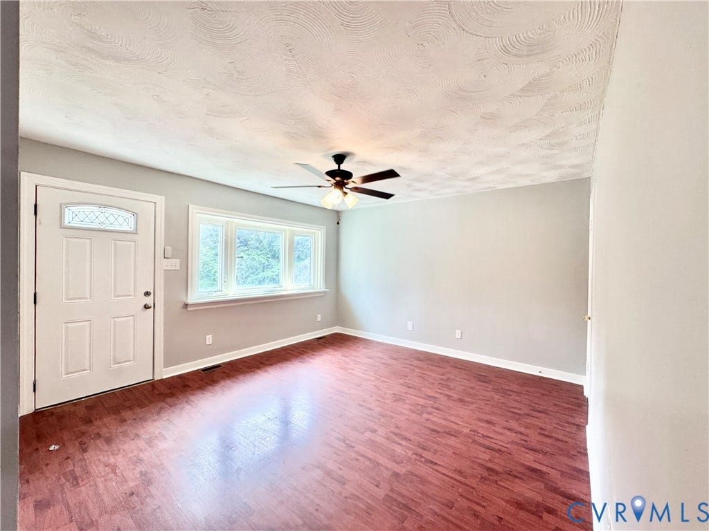 2711 Cheatham Street, Henderson & Johnson, Richmond, VA 23234 Wood-finish flooring, a multi-pane front door with decorative glass, and a large window with white trim