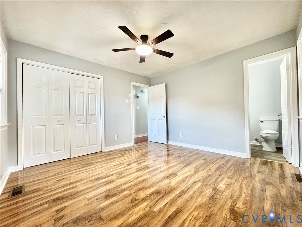 2711 Cheatham Street, Henderson & Johnson, Richmond, VA 23234 Wood-finish flooring, ceiling fan with integrated lighting, bi-fold closet doors, and light gray wall paint