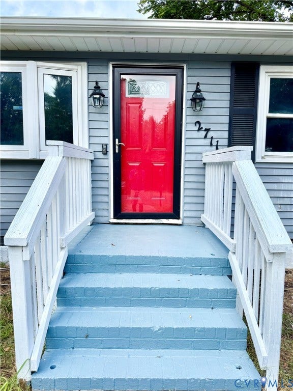 2711 Cheatham Street, Henderson & Johnson, Richmond, VA 23234 Exterior featuring horizontal siding, a red entry door, decorative outdoor lighting, and painted brick steps with handrails