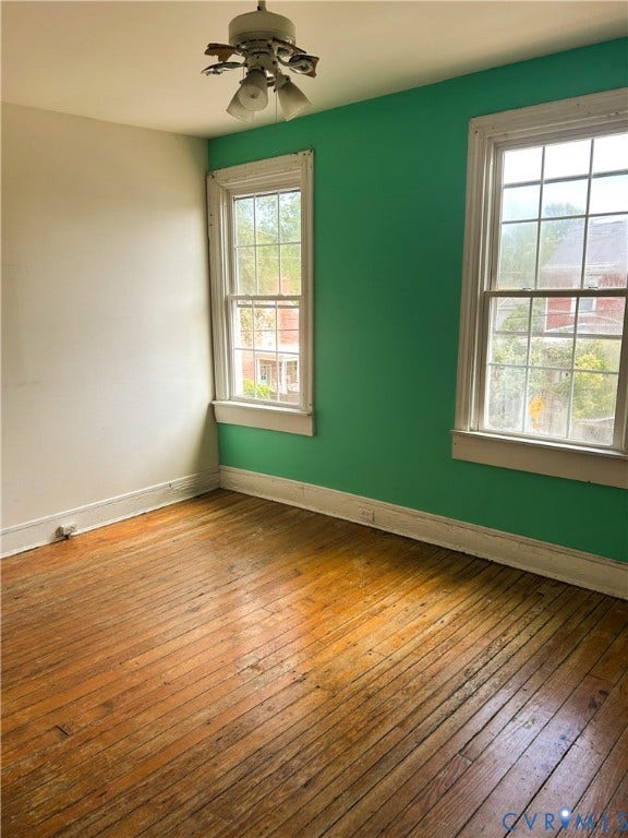 2709 E Clay Street, Church Hill, Richmond, VA 23223 Hardwood flooring, two single-hung windows with white trim, and a ceiling fan with light fixture