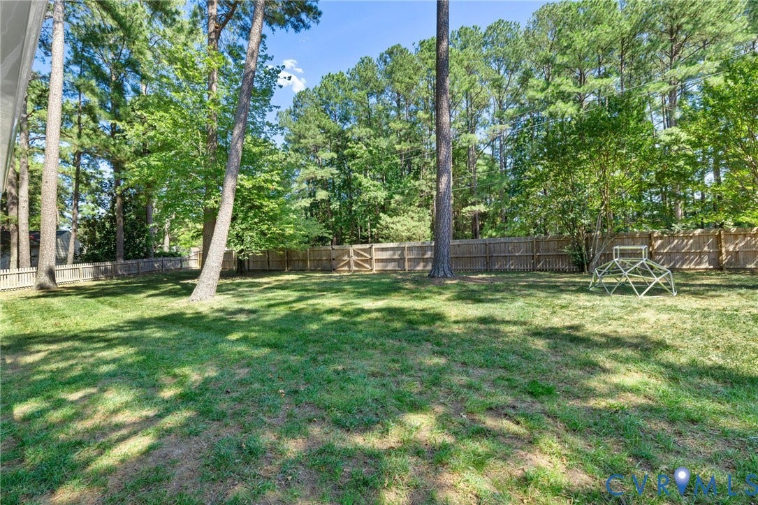 1109 Swissvale Place, Henrico, VA 23229 Expansive lawn area, mature trees, wood fence enclosure, and additional picket fencing