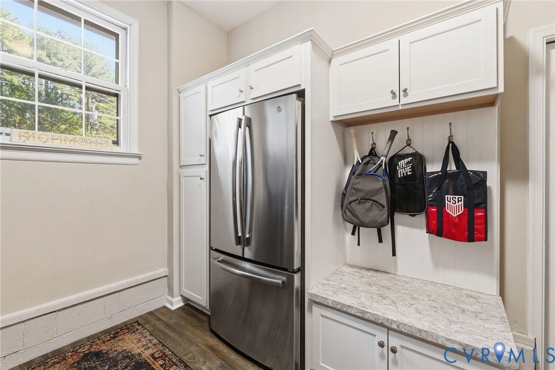 1109 Swissvale Place, Henrico, VA 23229 Stainless steel French door refrigerator, LVP flooring, white cabinetry with crown molding, built-in mudroom bench with textured countertop, and wall-mounted storage hooks