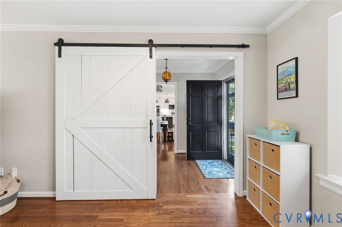 1109 Swissvale Place, Henrico, VA 23229 White barn door with black hardware, wood-finish flooring, crown molding, and a paneled black entry door