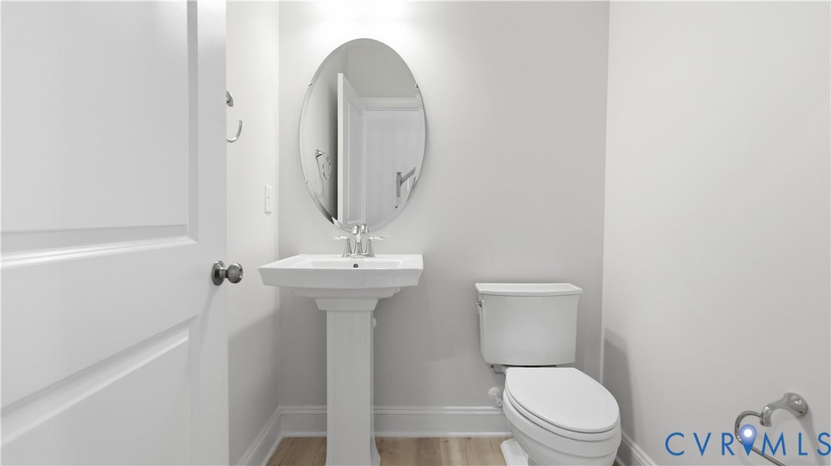 12344 Garnet Parke Circle, Short Pump Area, Glen Allen, VA 23059 Powder Room with Pedestal sink with chrome faucet, oval mirror, and wood-finish flooring