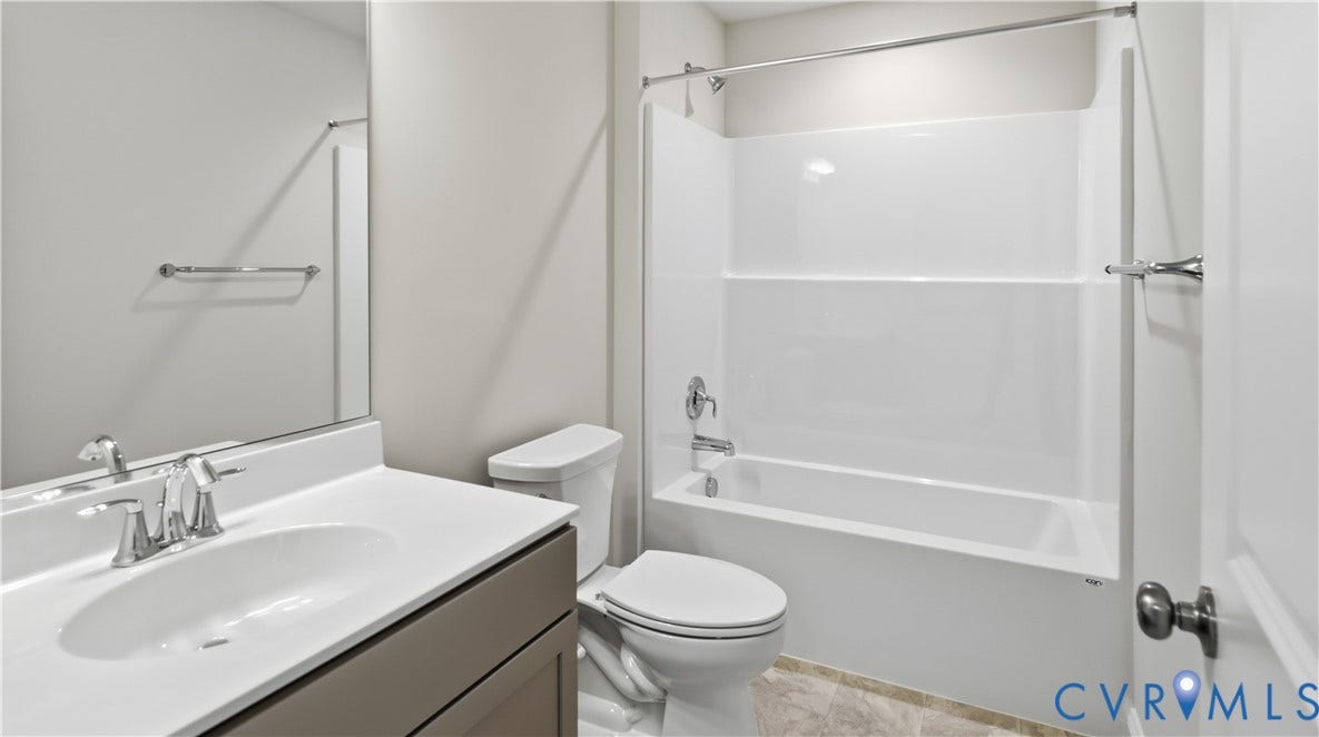 12344 Garnet Parke Circle, Short Pump Area, Glen Allen, VA 23059 Bathroom featuring a vanity with an integrated sink, polished chrome faucet, framed mirror, white toilet, and a combined tub and shower unit