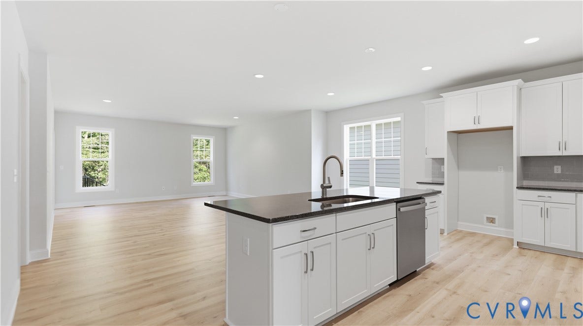 12344 Garnet Parke Circle, Short Pump Area, Glen Allen, VA 23059 Open-concept kitchen and living area featuring white cabinetry with chrome hardware, a black quartz island countertop with integrated sink, stainless steel appliances, recessed ceiling lighting, and wide-plank wood-finish flooring throughout
