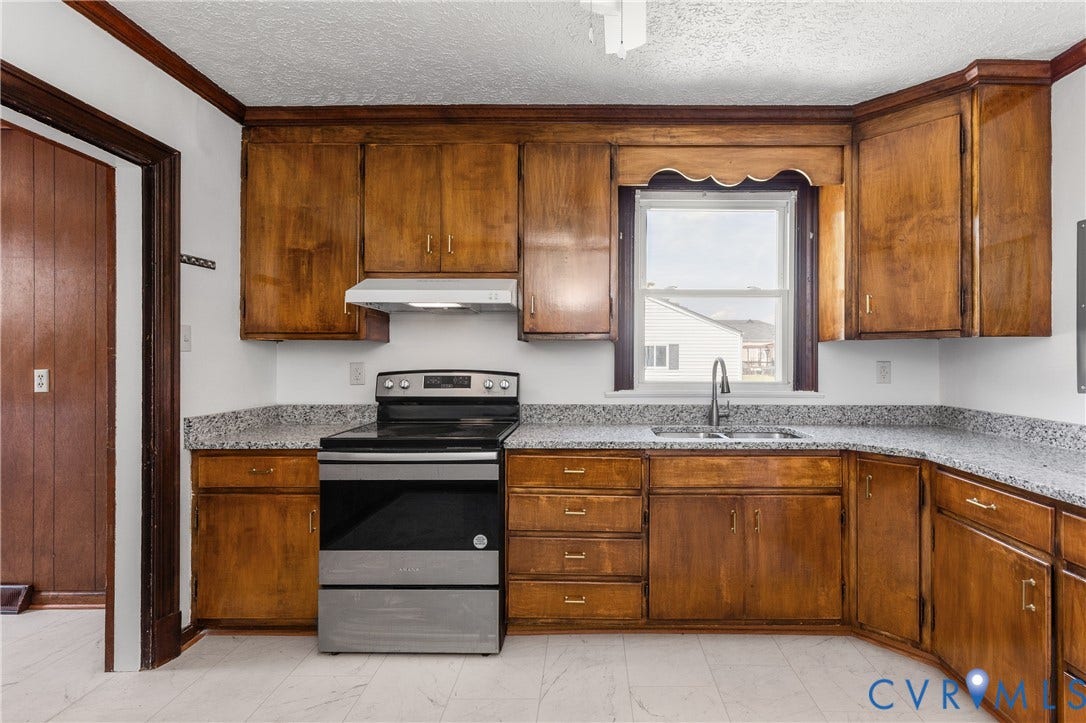 Kitchen featuring wood cabinetry, stainless steel range, and light-toned countertops
