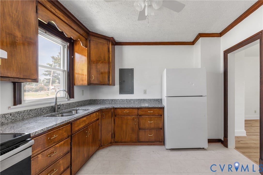 Kitchen featuring wood cabinetry, light-colored countertops, stainless steel sink with gooseneck faucet, and a ceiling fan