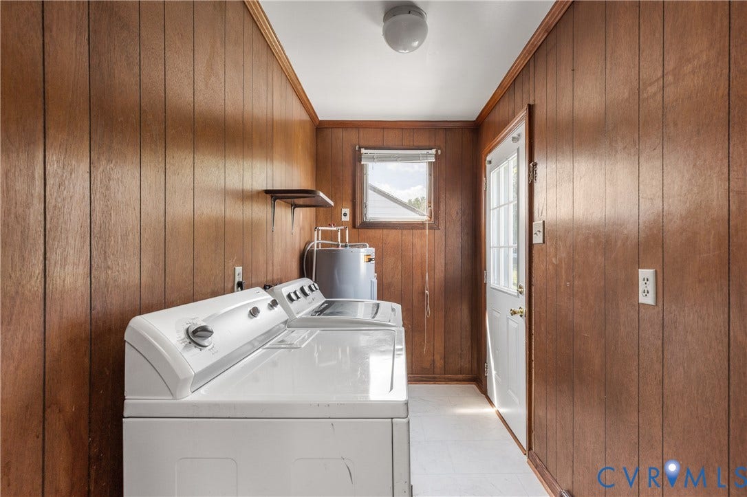 Laundry area featuring wood paneling, a ceiling-mounted light fixture, and a window with blinds