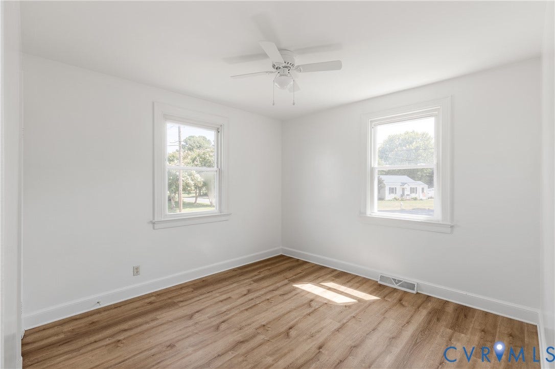 Bright interior space featuring wood-finish flooring and a ceiling fan