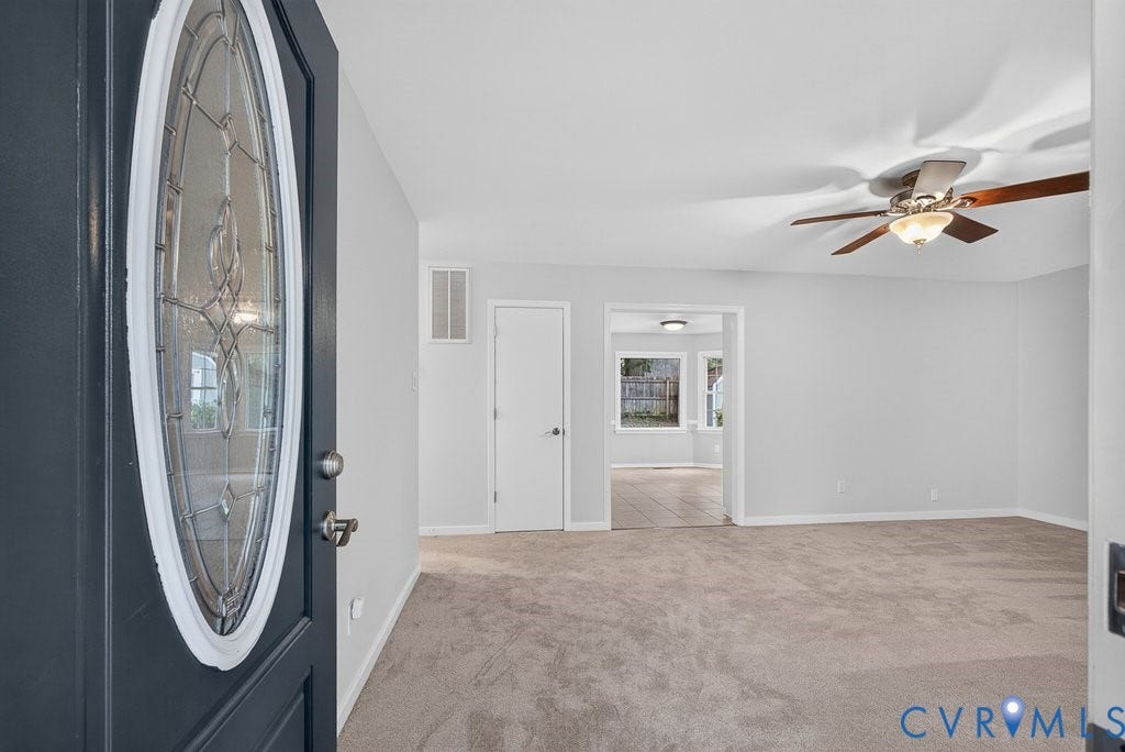 3112 Castlebury Drive, Chester, VA 23831 Oval leaded glass entry door, carpeted flooring, overhead ceiling fan with light fixture, light gray wall paint, and wood-finish flooring