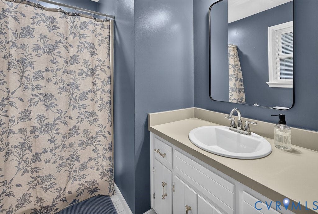 3112 Castlebury Drive, Chester, VA 23831 White vanity with cabinet storage, integrated oval sink, and a single-handle faucet