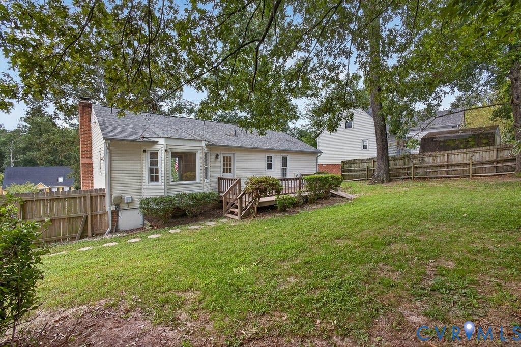 3112 Castlebury Drive, Chester, VA 23831 Expansive backyard featuring a sloped lawn, mature trees, and wood fencing