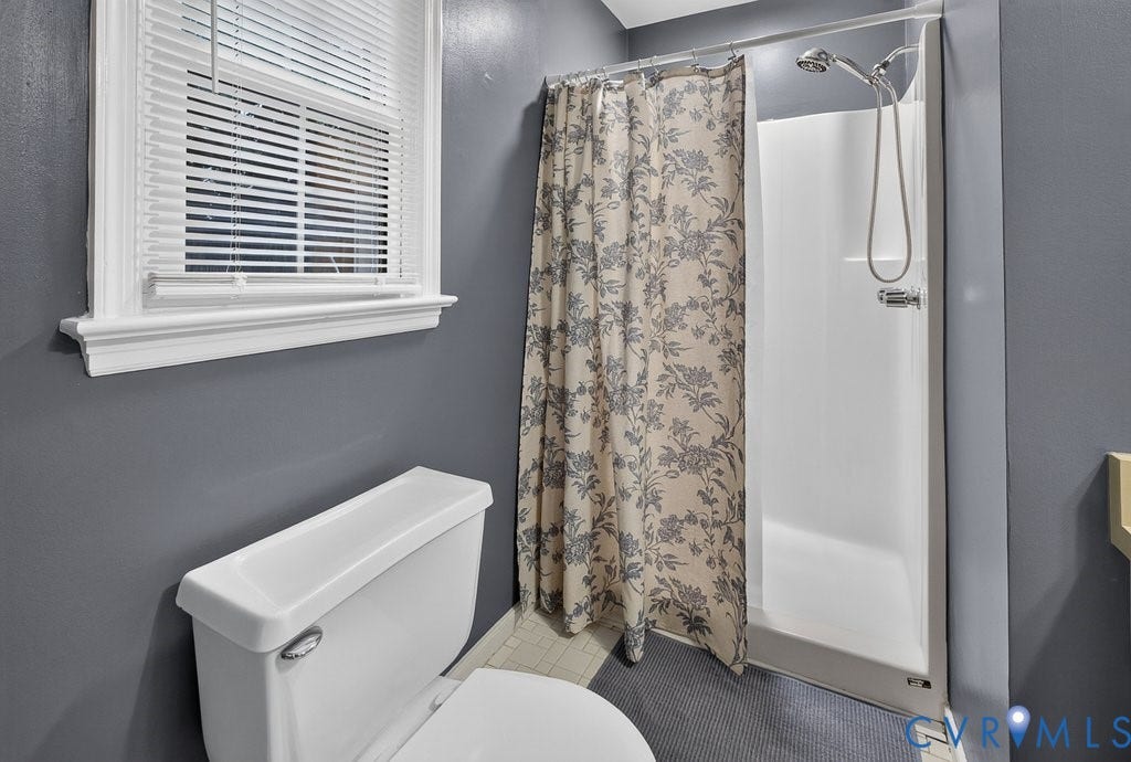 3112 Castlebury Drive, Chester, VA 23831 White window trim, white toilet, and a shower with a chrome fixture