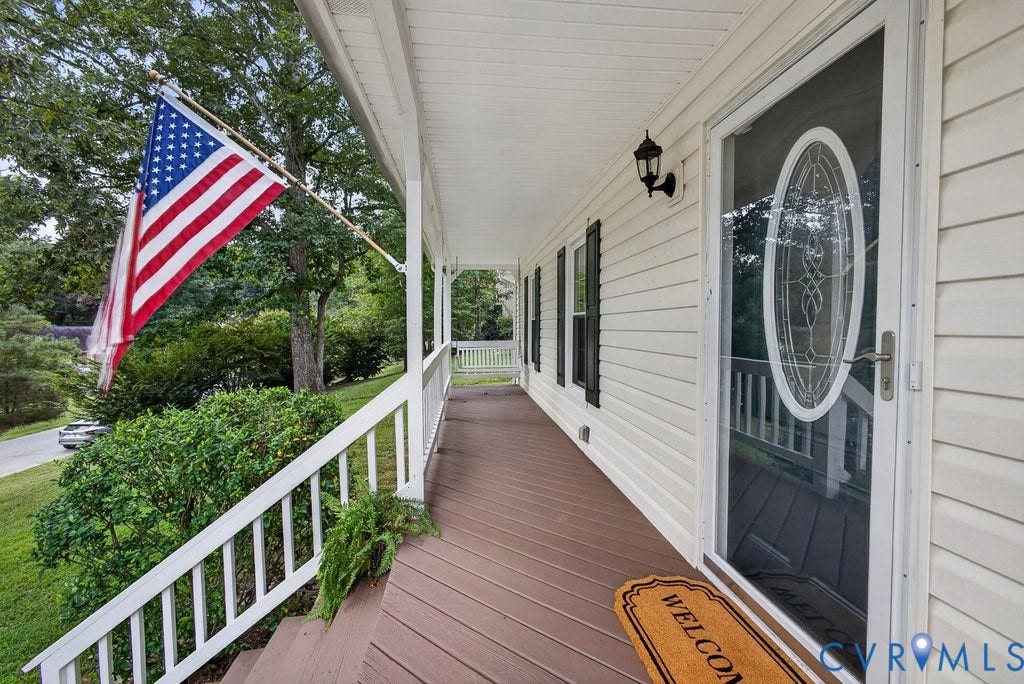 3112 Castlebury Drive, Chester, VA 23831 Expansive front porch featuring white vinyl siding, brown wood-finish decking, and a glass-paneled entry door