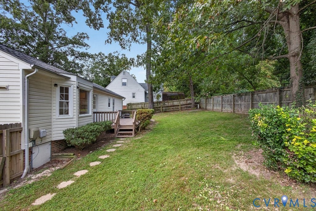 3112 Castlebury Drive, Chester, VA 23831 Expansive backyard featuring a wood deck, stone pathway, and privacy fencing
