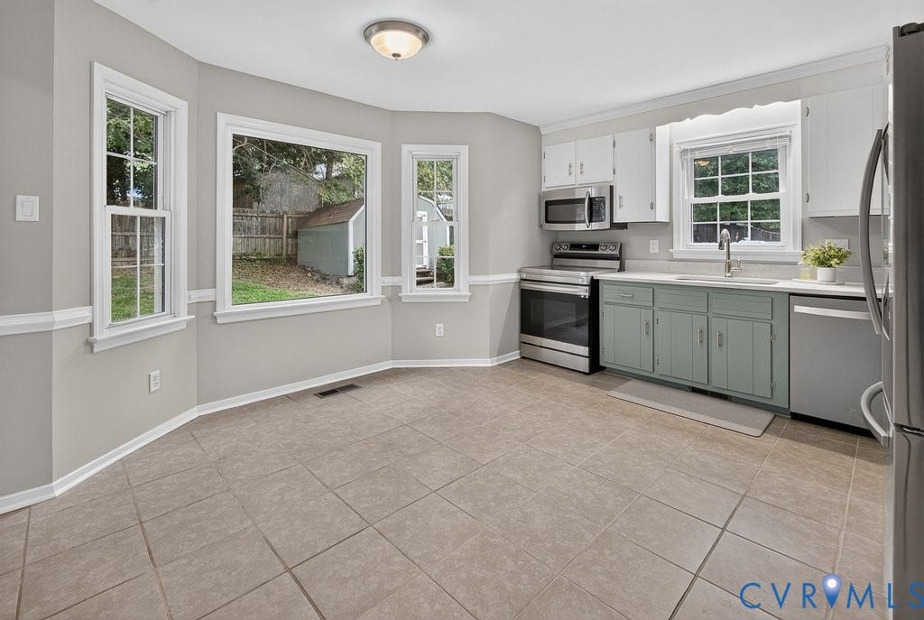 3112 Castlebury Drive, Chester, VA 23831 Kitchen featuring a stainless steel appliance suite, white upper cabinetry, sage lower cabinetry, and a light-toned countertop