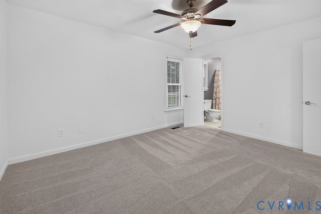 3112 Castlebury Drive, Chester, VA 23831 Light gray wall-to-wall carpeting, white walls, ceiling fan with integrated lighting, window with white trim, and a door leading to a bathroom