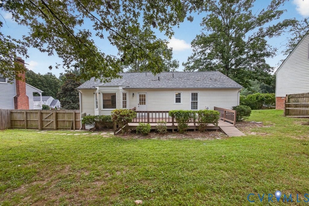 3112 Castlebury Drive, Chester, VA 23831 Expansive backyard featuring a manicured lawn, wood fencing, and a built-in wood deck with a ramp