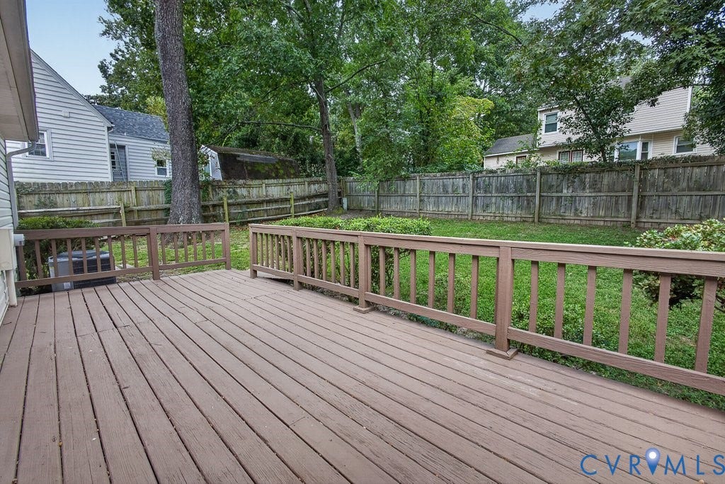 3112 Castlebury Drive, Chester, VA 23831 Expansive wooden deck featuring railings, a green lawn, mature trees, and a wooden fence