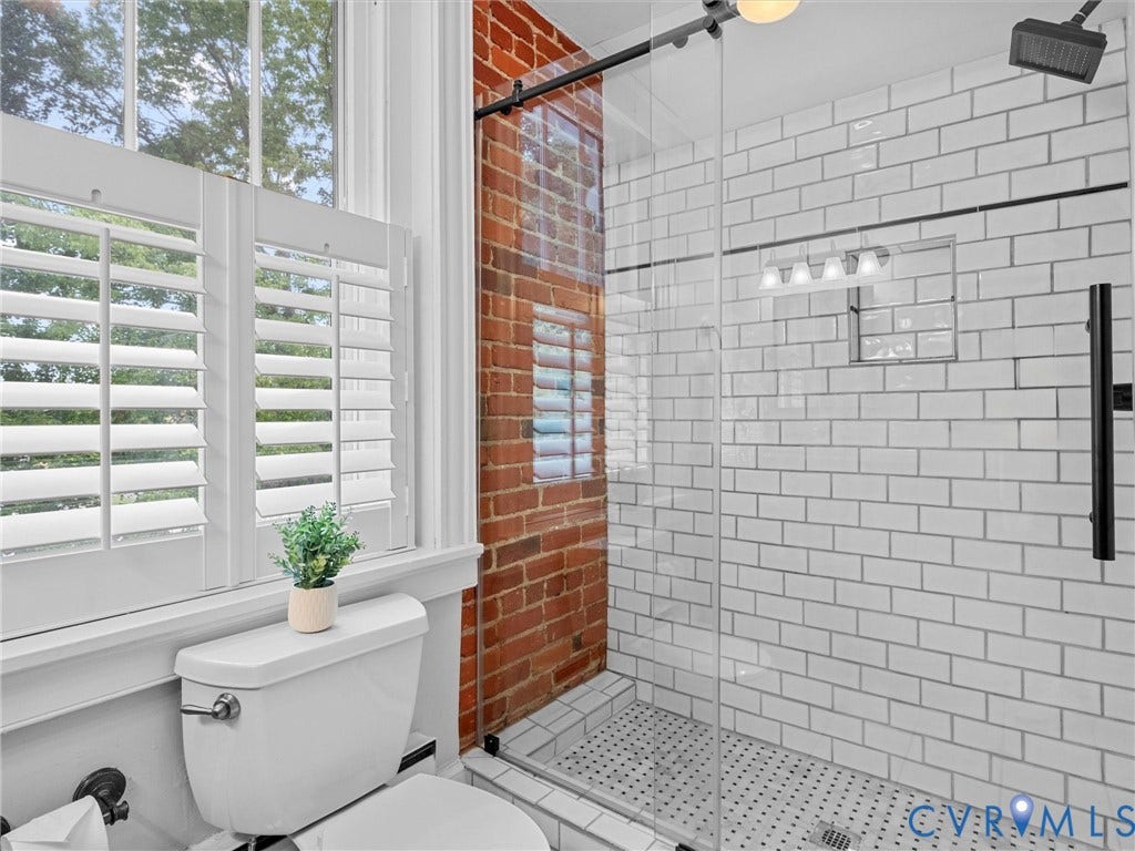 3403 W Franklin Street, Museum District, Richmond, VA 23221 White subway tile shower with a recessed niche, glass enclosure, and matte black fixtures