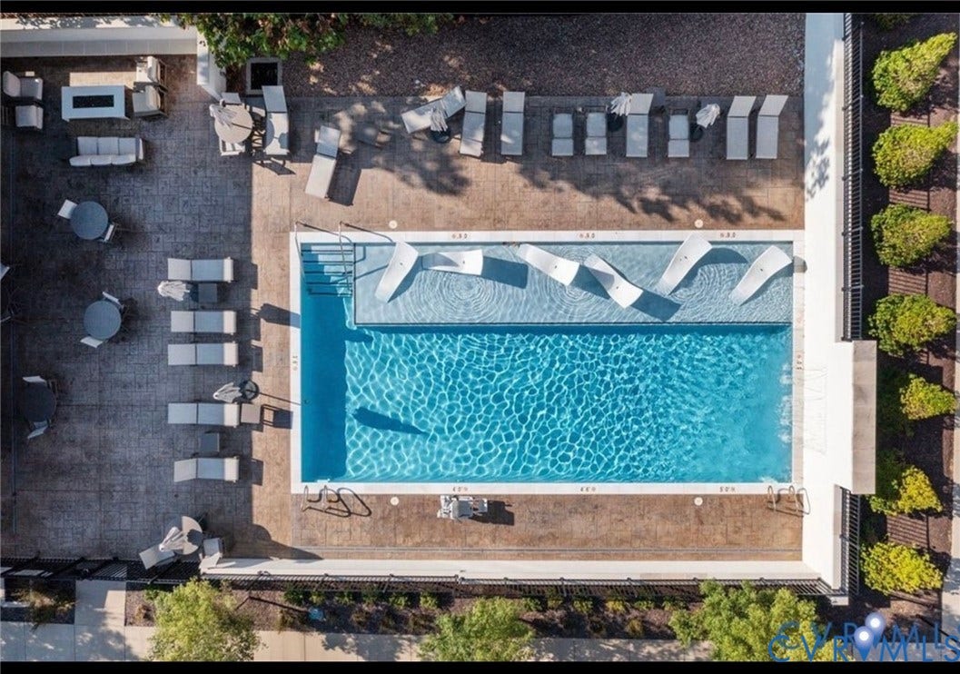 3332 Haydenpark Lane, Henrico, VA 23233 Rectangular swimming pool with a Baja shelf, integrated in-pool lounge chairs, surrounding paver patio, and stone aggregate landscaping
