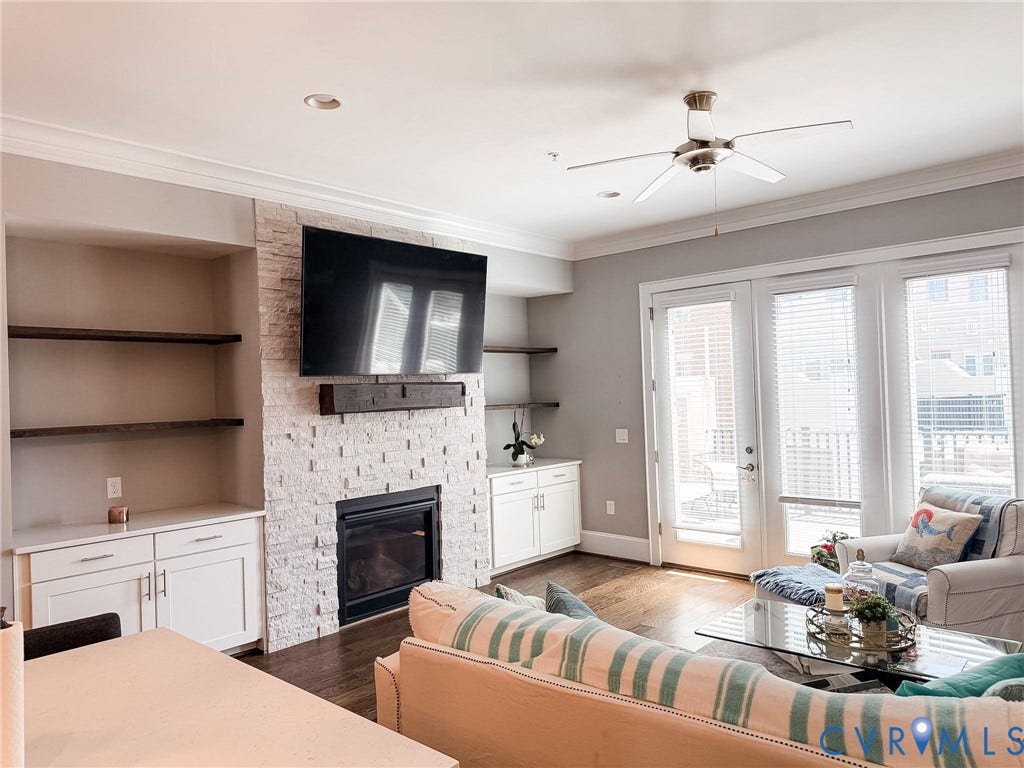 3332 Haydenpark Lane, Henrico, VA 23233 Stacked stone fireplace with a wood mantel, built-in shelving, white cabinetry, dark wood-finish flooring, and French doors