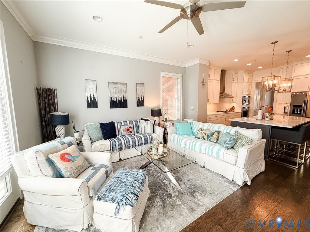 3332 Haydenpark Lane, Henrico, VA 23233 Open-concept living area featuring rich wood-finish flooring, a modern ceiling fan, recessed lighting, crown molding, and a kitchen with stainless steel appliances and pendant lighting