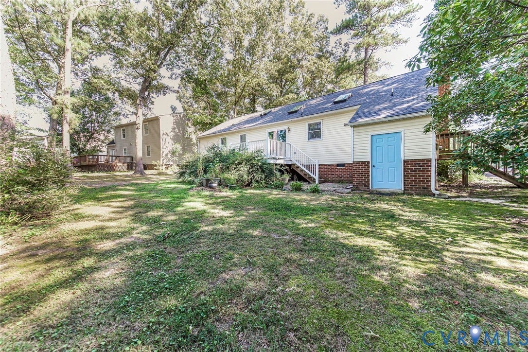 Spacious rear yard with mature trees and a multi-level deck
