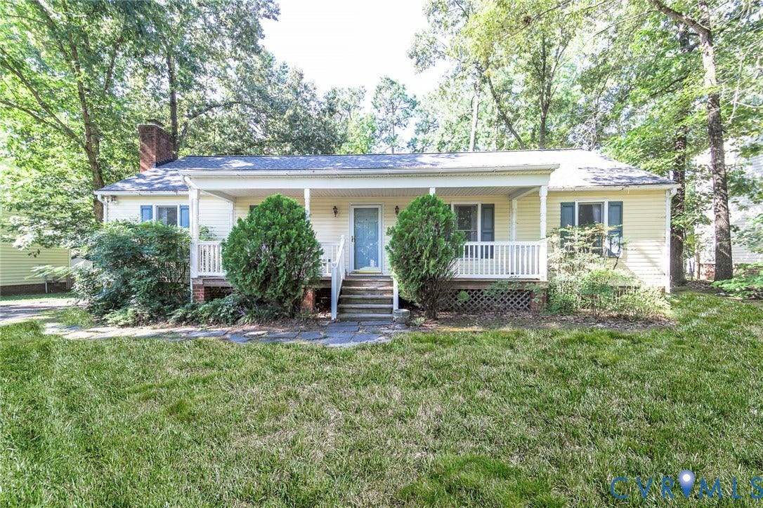 Single-story residence featuring light-colored siding, a covered front porch with white railing, and exterior steps leading to a front entry